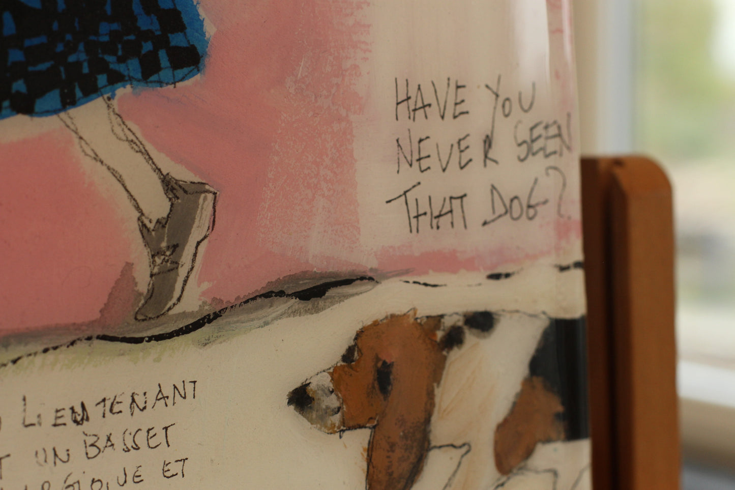 Tableau original carré "Have You Never Seen That Dog?" de l'artiste Béatrice Graas. Œuvre en technique mixte sur bois avec finition résine brillante, représentant un Basset Hound, une silhouette féminine en jupe écossaise bleue et noire avec une "laisse" collée, et des inscriptions calligraphiées spontanées sur un fond abstrait rose et beige.
