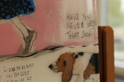 Tableau original carré "Have You Never Seen That Dog?" de l'artiste Béatrice Graas. Œuvre en technique mixte sur bois avec finition résine brillante, représentant un Basset Hound, une silhouette féminine en jupe écossaise bleue et noire avec une "laisse" collée, et des inscriptions calligraphiées spontanées sur un fond abstrait rose et beige.
